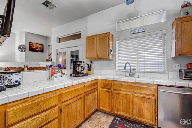 kitchen featuring visible vents, light tile patterned flooring, a sink, light countertops, and dishwasher