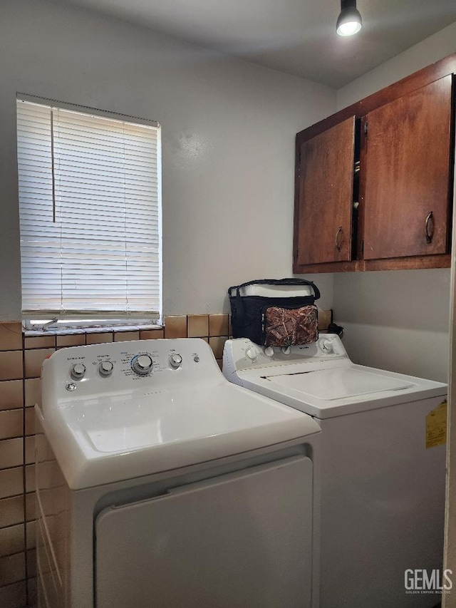 laundry area featuring washer and dryer and cabinets