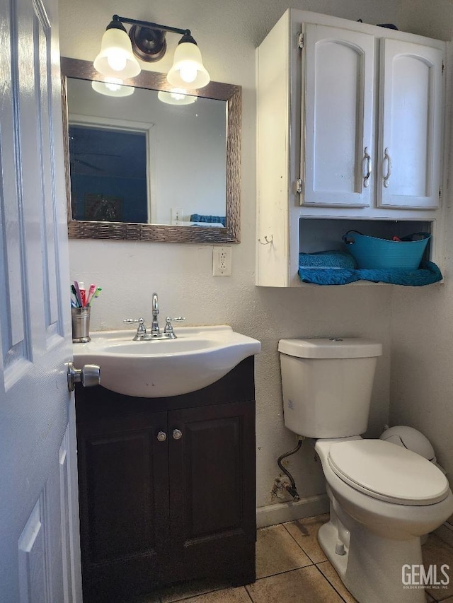 bathroom with vanity, tile patterned flooring, and toilet