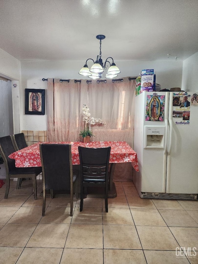 tiled dining area with a chandelier