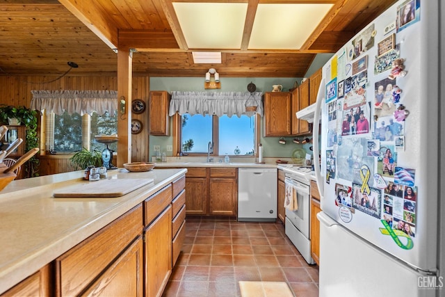 25001 Cannonero Ct, Tehachapi, CA 93561 - kitchen featuring white appliances, wooden ceiling, light countertops, brown cabinetry, and under cabinet range hood