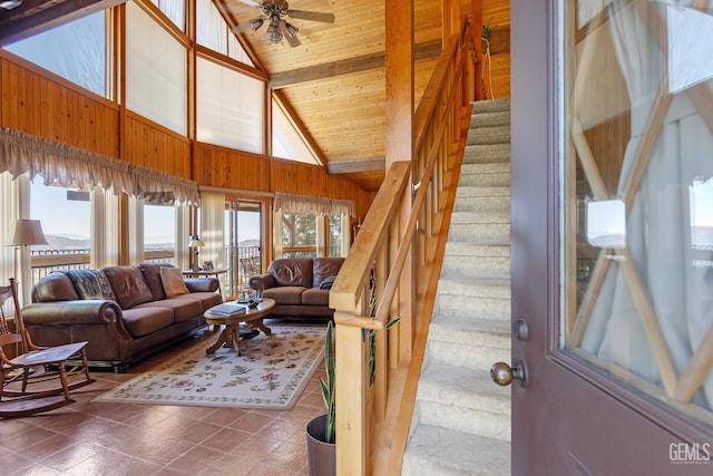 25001 Cannonero Ct, Tehachapi, CA 93561 - living room featuring plenty of natural light, stairs, ceiling fan, wooden walls, and high vaulted ceiling
