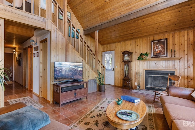 25001 Cannonero Ct, Tehachapi, CA 93561 - living area featuring wooden walls, tile patterned flooring, stairs, a wood ceiling with exposed beams, and a glass covered fireplace