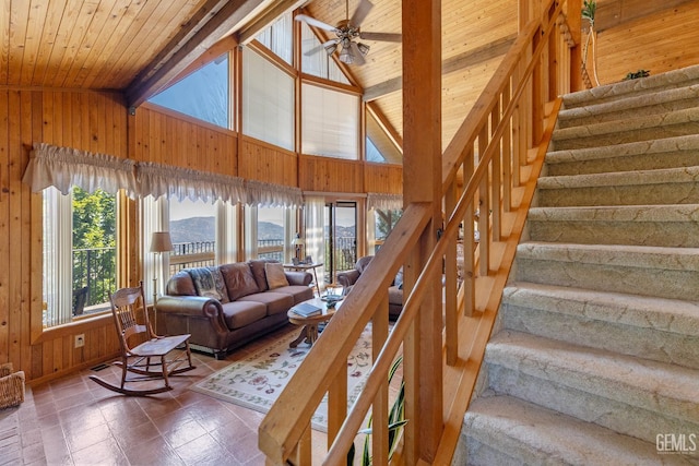 25001 Cannonero Ct, Tehachapi, CA 93561 - living area with wooden walls, a wood ceiling with exposed beams, stairs, a ceiling fan, and high vaulted ceiling