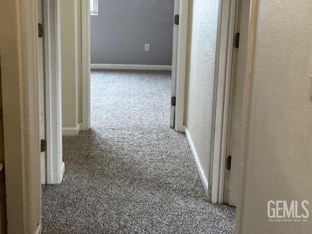 hallway with baseboards and carpet floors