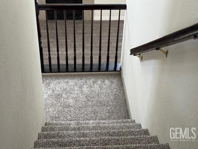 stairway with a textured wall and carpet