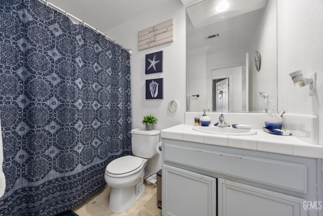 bathroom featuring vanity, toilet, and curtained shower