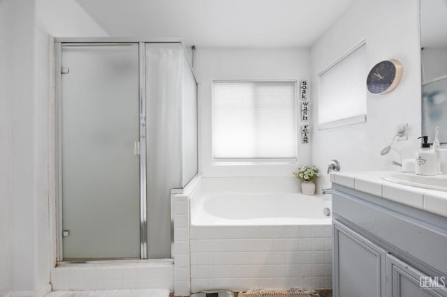 bathroom with vanity and shower with separate bathtub