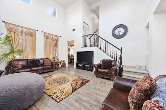 living room featuring light hardwood / wood-style flooring and a high ceiling