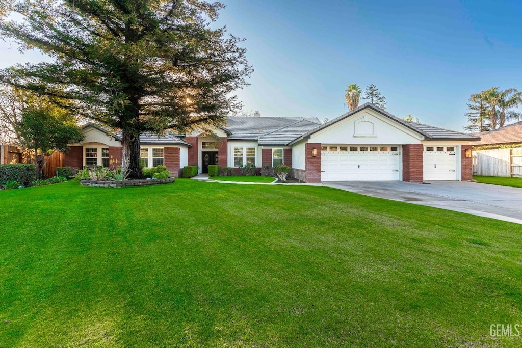 single story home featuring a front lawn and a garage