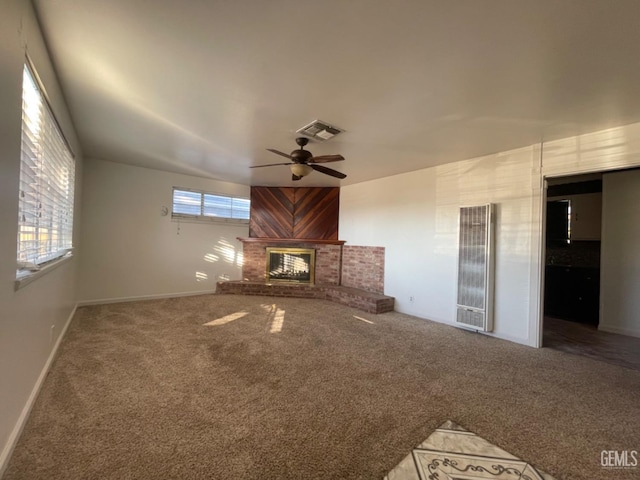 unfurnished living room featuring wooden walls, a fireplace, carpet, and ceiling fan