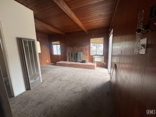 unfurnished living room featuring carpet, beam ceiling, wood ceiling, wood walls, and a brick fireplace