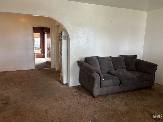 carpeted living area featuring cooling unit and arched walkways