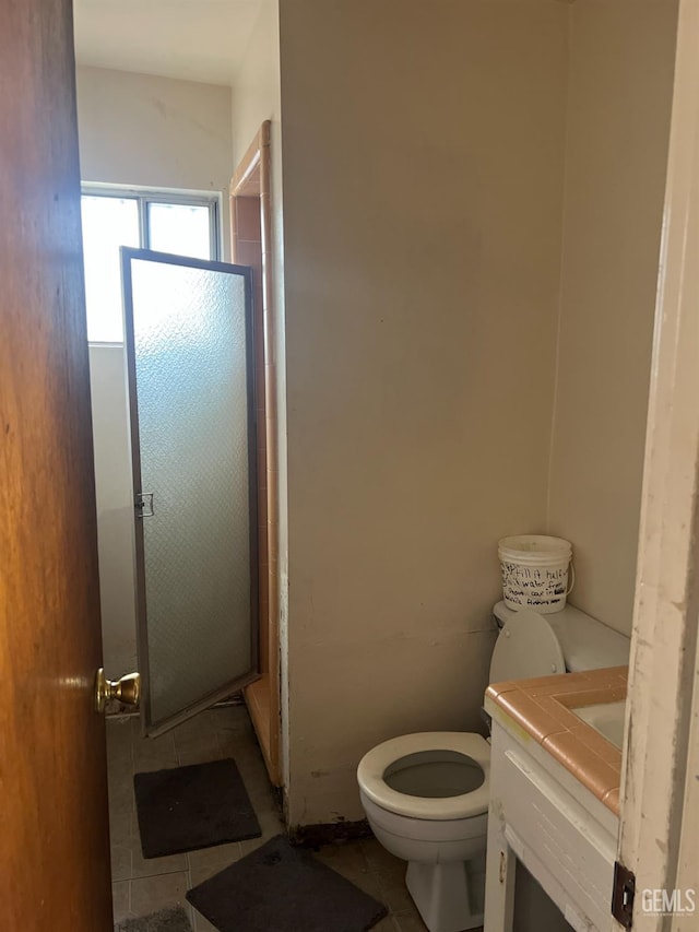 full bathroom featuring vanity, a shower stall, toilet, and tile patterned floors