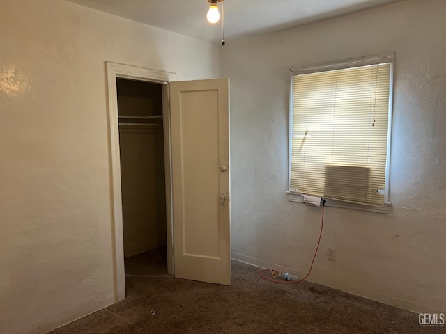 unfurnished bedroom with a closet, carpet floors, and a textured wall