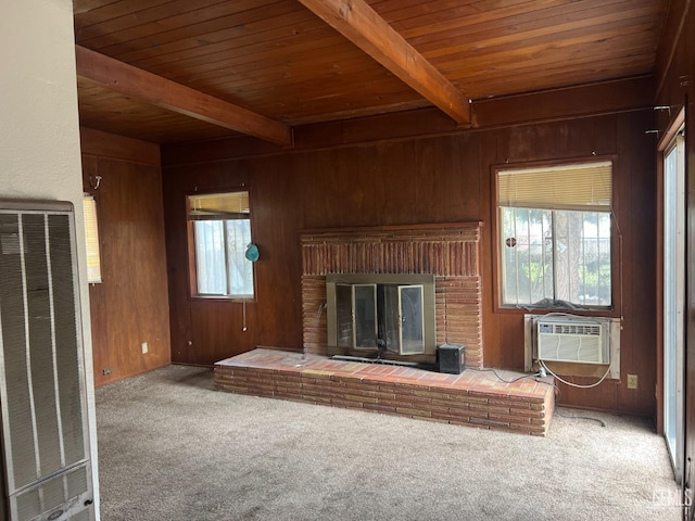 unfurnished living room featuring beam ceiling, wood ceiling, wood walls, and carpet floors