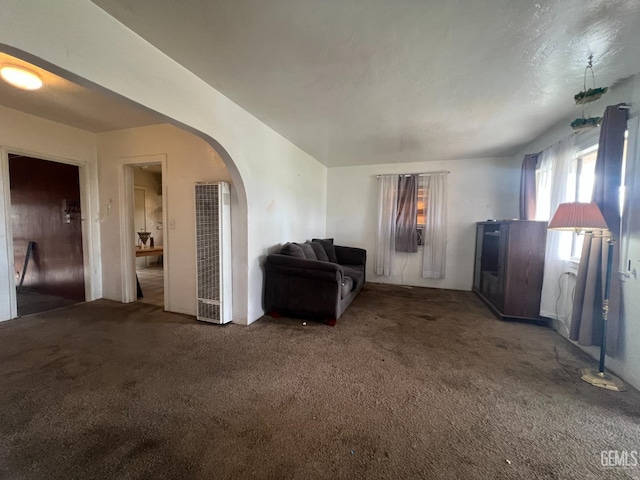 living area featuring arched walkways and carpet floors