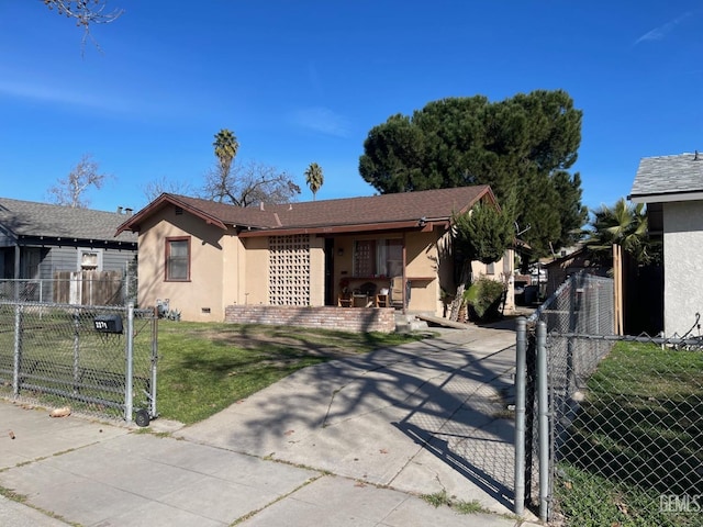 view of front of property with a gate, stucco siding, a front lawn, and fence