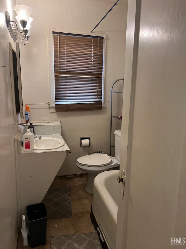 full bathroom featuring tile patterned flooring, a tub, toilet, and vanity