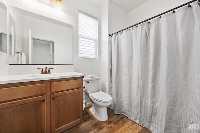 bathroom with toilet, vanity, and hardwood / wood-style floors