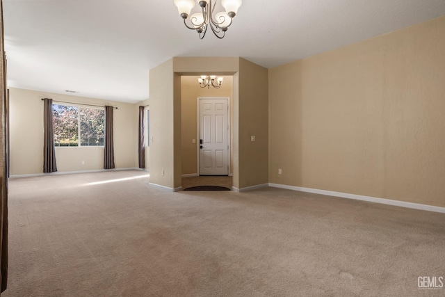 unfurnished room featuring baseboards, carpet flooring, and an inviting chandelier