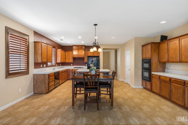 kitchen with brown cabinetry, baseboards, and black appliances