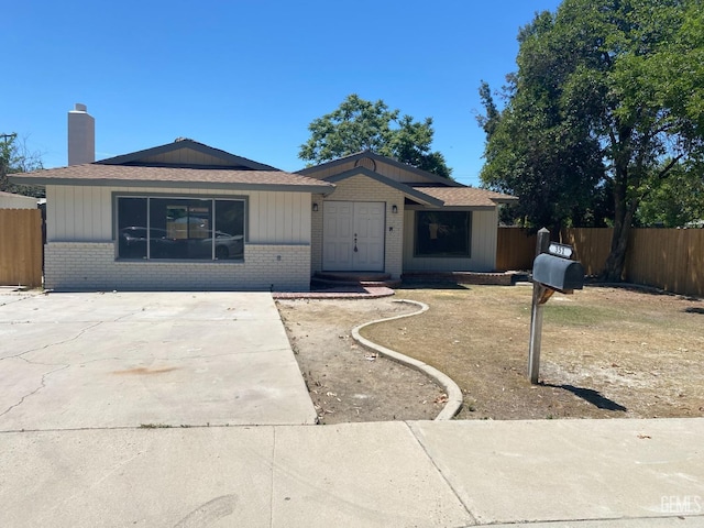 351 Adams St, Wasco, CA 93280 - ranch-style house with brick siding, fence, a chimney, and a shingled roof