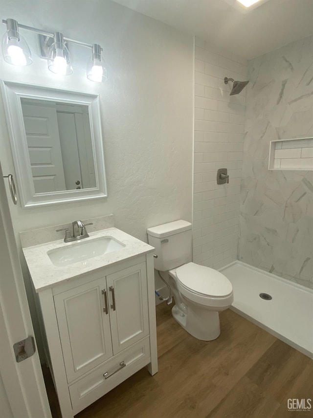 351 Adams St, Wasco, CA 93280 - full bathroom with wood finished floors, vanity, a shower stall, toilet, and a textured wall
