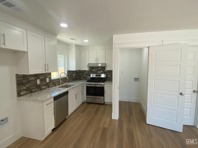 351 Adams St, Wasco, CA 93280 - kitchen with stainless steel appliances, a sink, under cabinet range hood, decorative backsplash, and dark wood-style floors