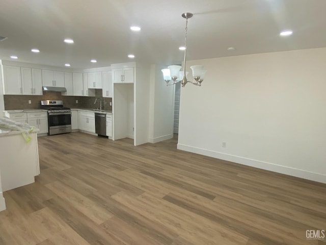 351 Adams St, Wasco, CA 93280 - kitchen featuring stainless steel appliances, under cabinet range hood, a chandelier, baseboards, and a sink