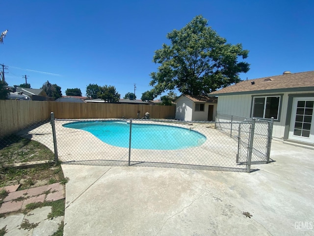 351 Adams St, Wasco, CA 93280 - view of swimming pool with a fenced backyard, a patio, an outdoor structure, and a storage unit