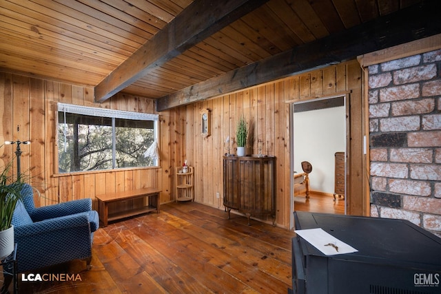 sitting room featuring beamed ceiling, wooden walls, and hardwood / wood-style flooring