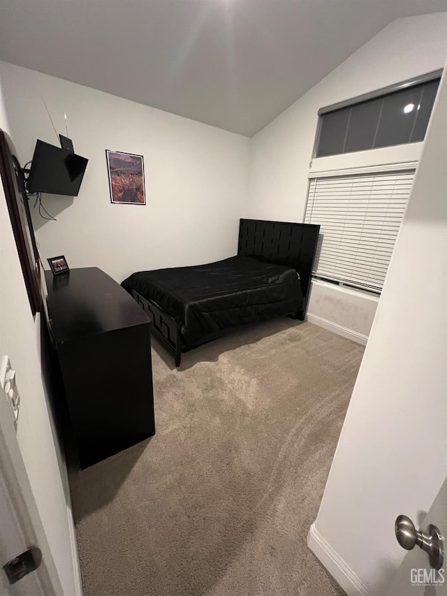 bedroom featuring light colored carpet and lofted ceiling