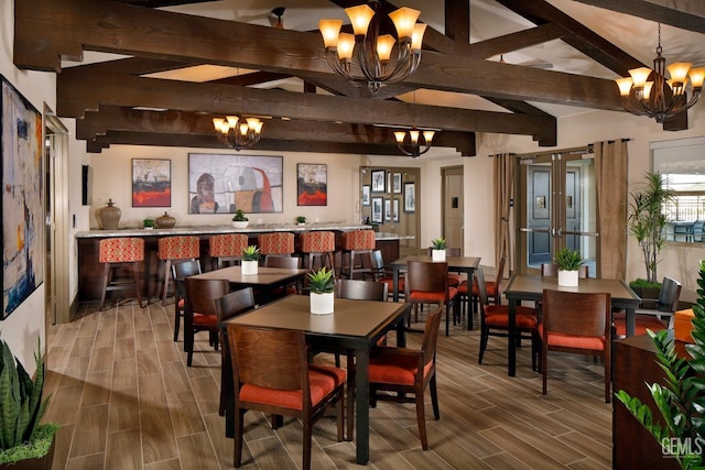 dining space featuring wood tiled floor, beam ceiling, french doors, and an inviting chandelier