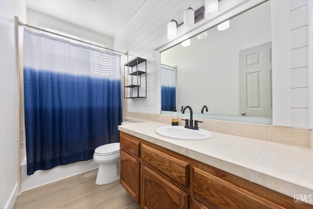 full bathroom with vanity, hardwood / wood-style floors, shower / bath combination with curtain, and toilet