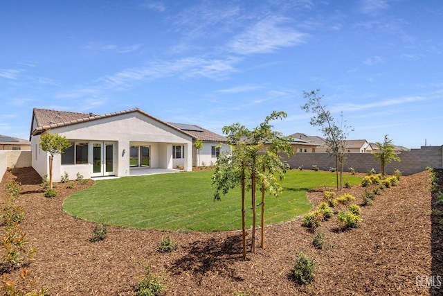 back of property featuring stucco siding, a patio area, a yard, and a fenced backyard