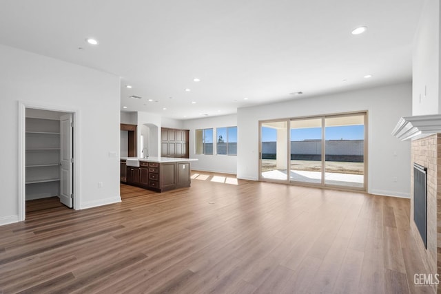 unfurnished living room with a brick fireplace and hardwood / wood-style floors