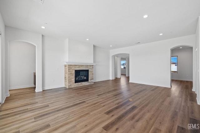 unfurnished living room with light hardwood / wood-style flooring and a tiled fireplace