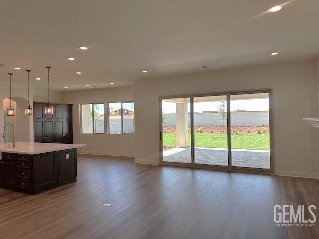 kitchen featuring baseboards, recessed lighting, dark wood-style flooring, and light countertops