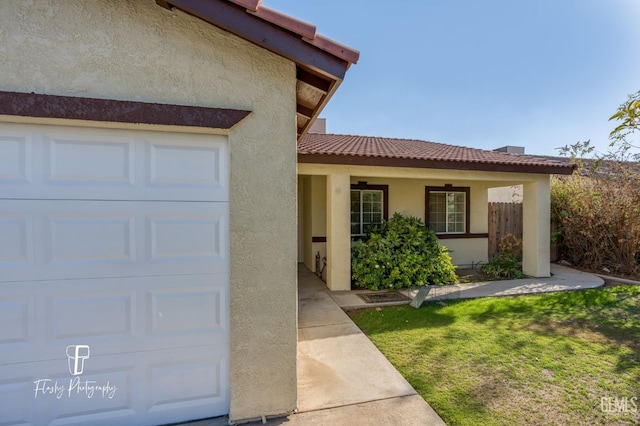 doorway to property featuring a yard and a garage