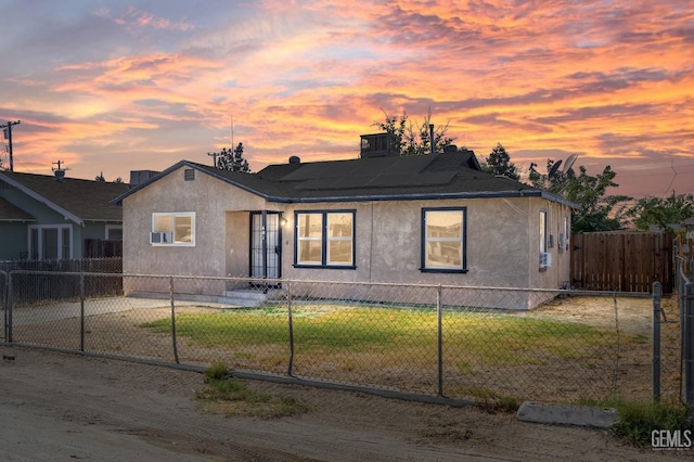 view of front facade featuring solar panels, a yard, and central AC