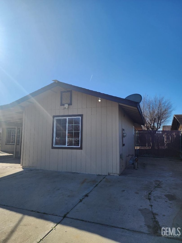 view of property exterior featuring a patio area and fence