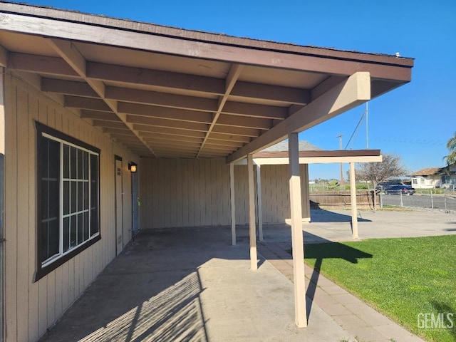 view of patio featuring a carport and fence