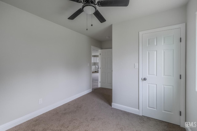 unfurnished bedroom with carpet flooring, a ceiling fan, and baseboards