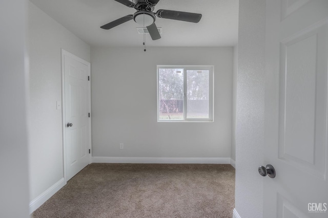 spare room with carpet floors, ceiling fan, and baseboards