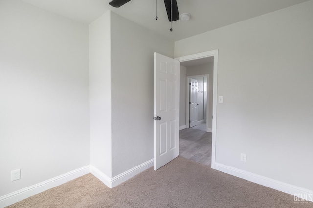 empty room featuring baseboards and light colored carpet