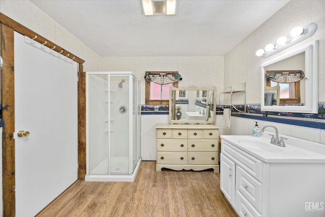 45071 Forest Dr, Posey, CA 93260 - bathroom with a stall shower, wood finished floors, two vanities, and a wainscoted wall