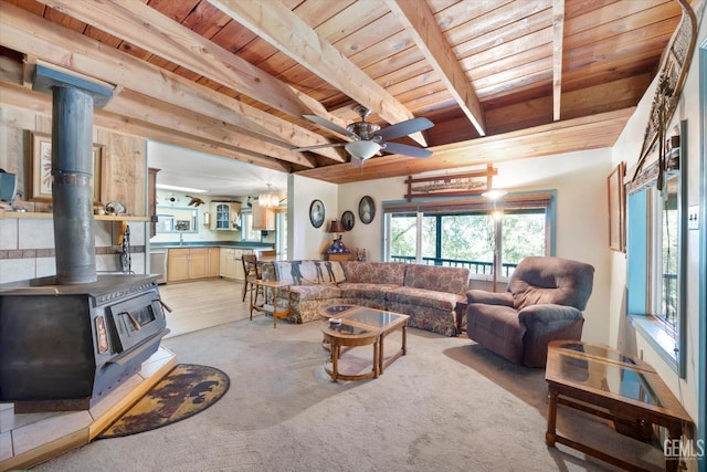 45071 Forest Dr, Posey, CA 93260 - living room featuring a wood ceiling with exposed beams, a ceiling fan, a wood stove, and light colored carpet