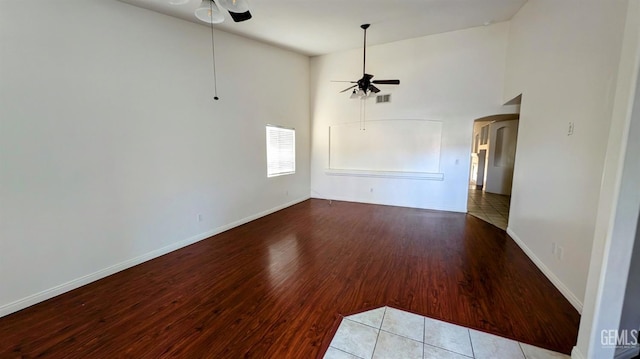 unfurnished living room with high vaulted ceiling, tile patterned floors, and ceiling fan