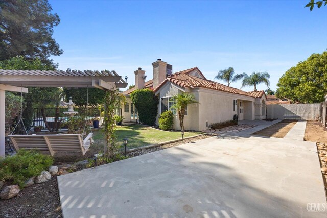 7601 Live Oak Way, Bakersfield, CA 93308 - view of side of property featuring stucco siding, a chimney, a tiled roof, a patio, and driveway